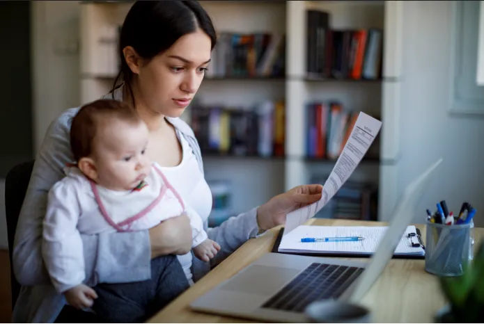 Femme chercheuse en télétravail avec un jeune enfant durant le confinement